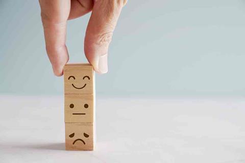 Wooden blocks with smiley, neutral and sad faces on